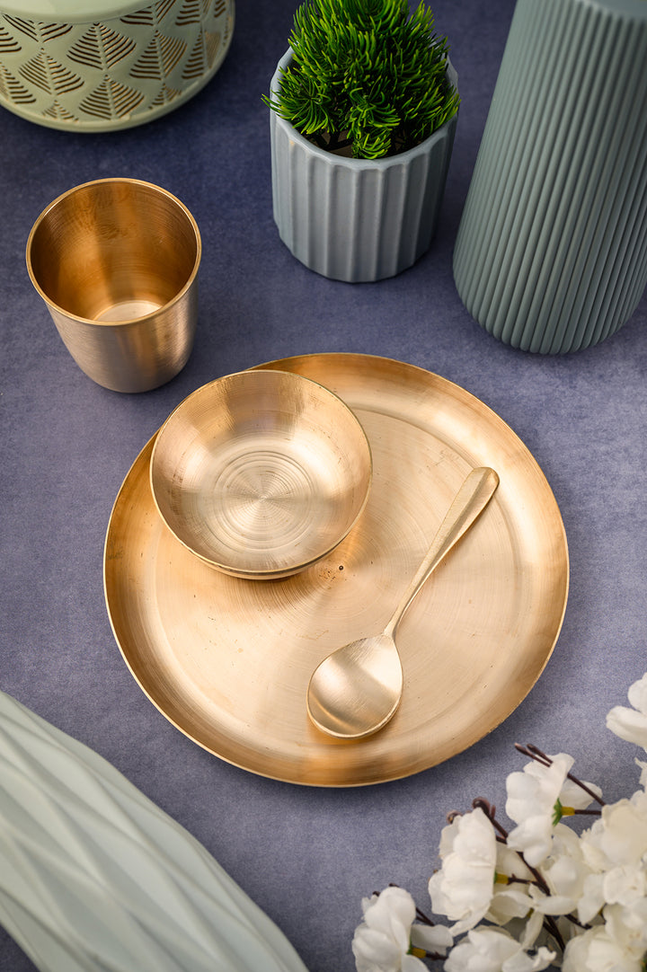 Kansa Baby Dinner Set / Baby Gift Set consisting of a bronze plate, bowl, spoon, and glass on a stylish table setting.