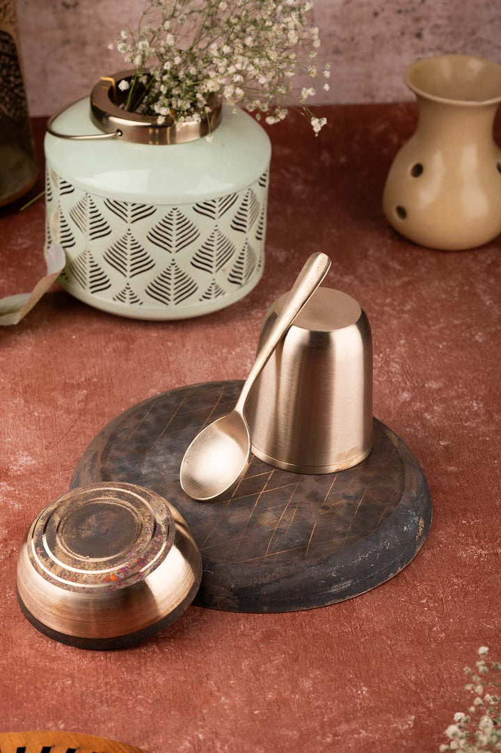 Kansa Baby Dinner Set / Baby Gift Set featuring a bronze plate, bowl, spoon, and glass, elegantly arranged on a wooden surface.